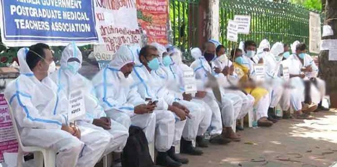 ശമ്പള കുടിശിക വേണം ; പിപിഇ കിറ്റ് ധരിച്ച് സമരത്തിനിറങ്ങി ഡോക്ടർമാർ ശമ്പള കുടിശിക വേണം ; പിപിഇ കിറ്റ് ധരിച്ച് സമരത്തിനിറങ്ങി ഡോക്ടർമാർ
